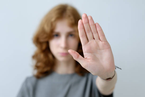 istock A red-haired girl with curls puts forward her hand. 694385552