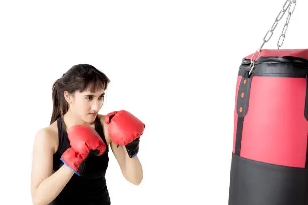 Picture of a beautiful woman exercising with a boxing sack, isolated on white background