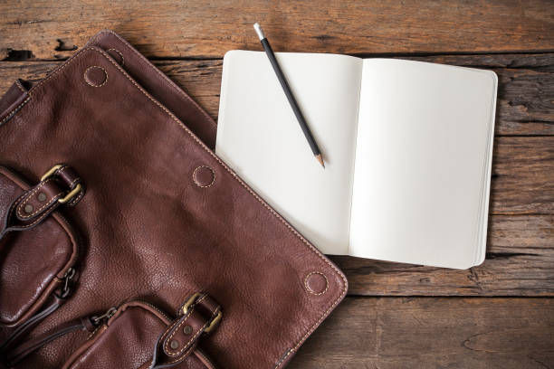 istock blank notebook with leather bag on wooden table 694389542