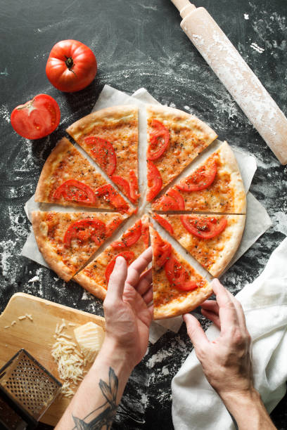 istock Delicious pizza with tomato on dark background 694390220