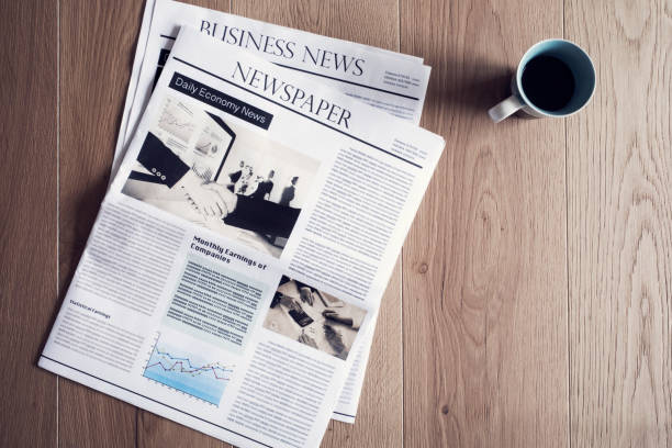 istock Newspaper on wooden table 694390312