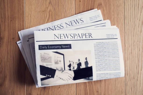 istock Newspaper on wooden table 694396392