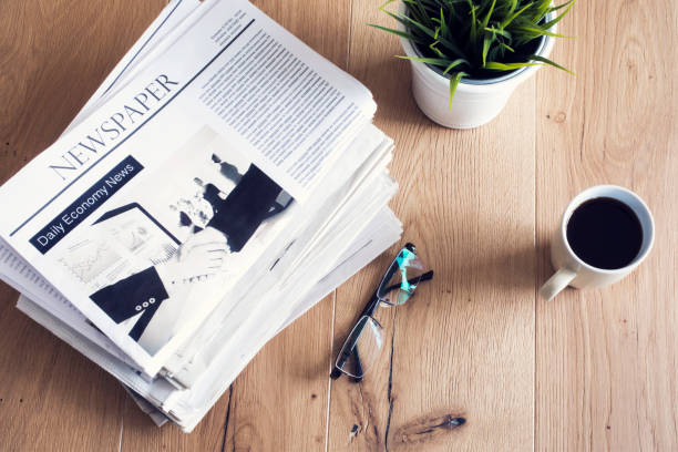 istock Newspaper on wooden table 694399402