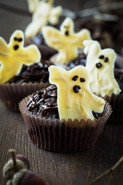 istock Chocolate muffins with  sweet white chocolate ghosts 694403000