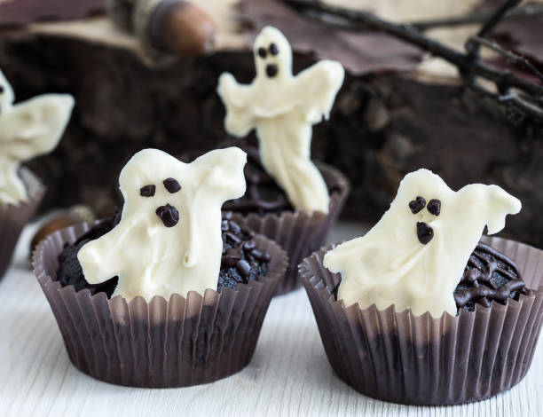 istock Chocolate muffins with  sweet white chocolate ghosts 694403058