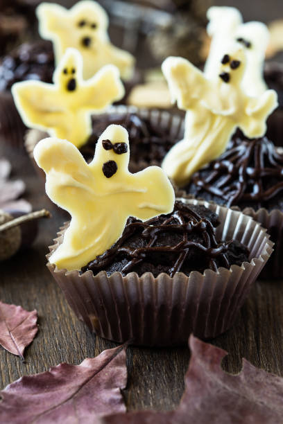 istock Chocolate muffins with  sweet white chocolate ghosts 694403062