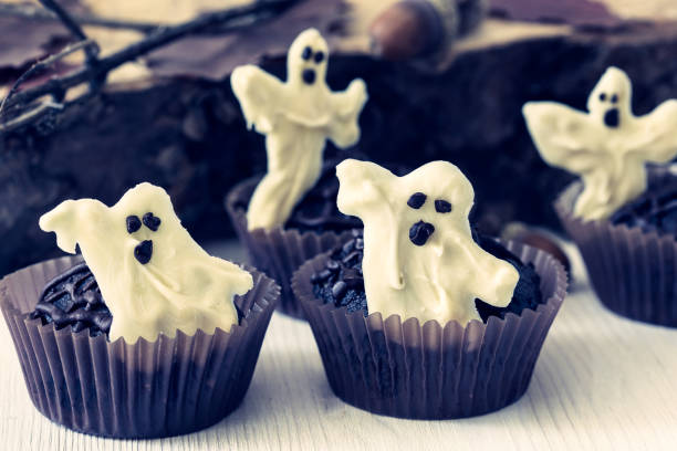 istock Chocolate muffins with  sweet white chocolate ghosts 694403738