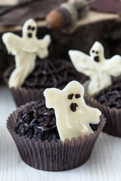 istock Chocolate muffins with  sweet white chocolate ghosts 694405108