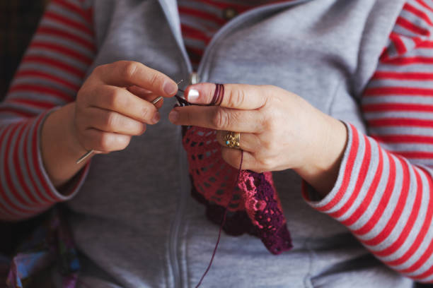 istock Old women crocheting beautiful art-peace 694408620