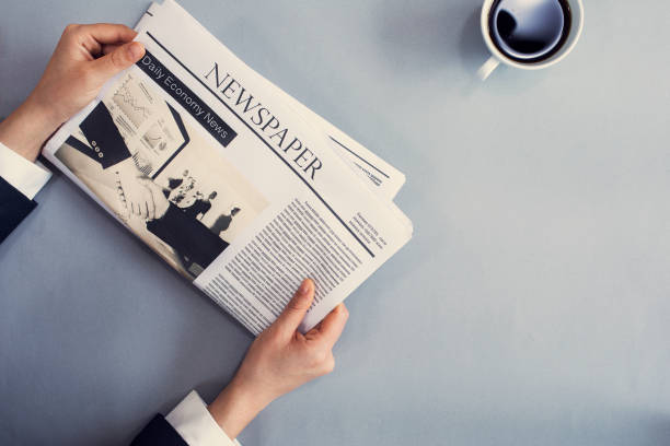 istock Reading newspaper on desk 694408760