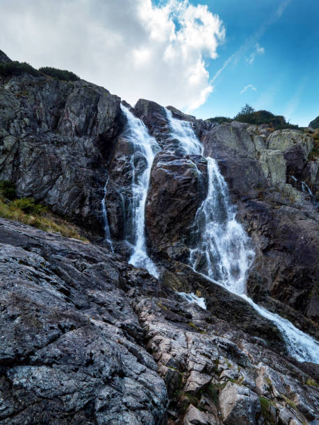 istock Panorama of mountains with a waterfall 694409526