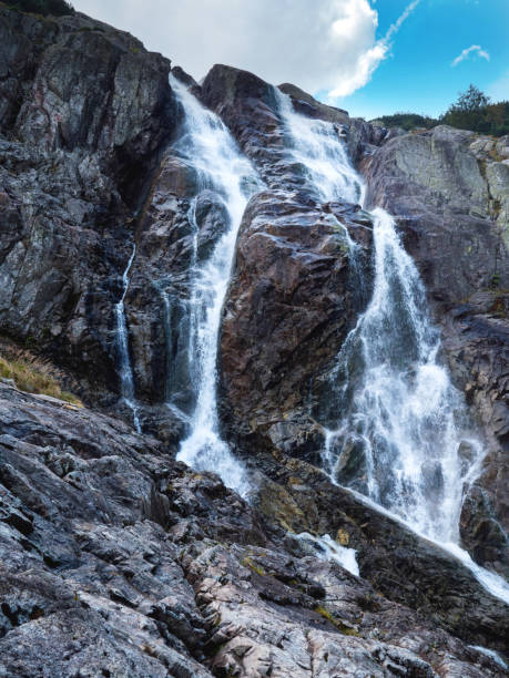 istock Panorama of mountains with a waterfall 694409612