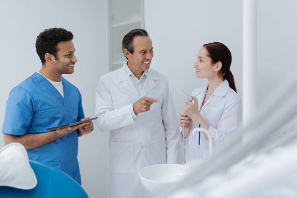 istock Successful stomatologist talking with his assistants 694422010
