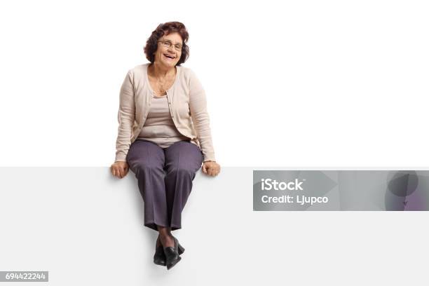 Senior Mujer Sentada En Un Panel Foto de stock y más banco de imágenes de Sentado - Sentado, Una sola mujer, Recortable