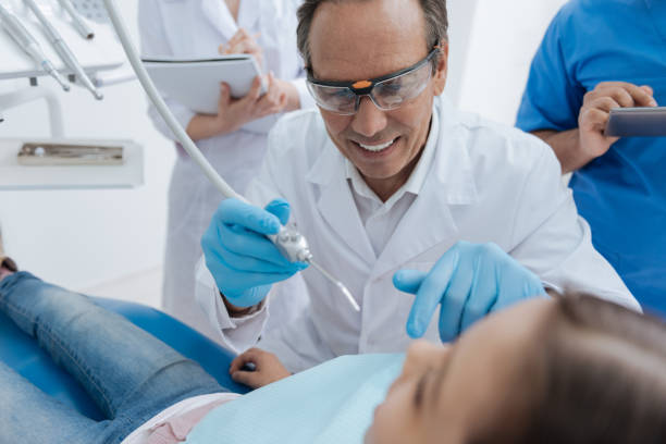 istock Portrait of competent dentist while repairing one problem in mouth 694422412
