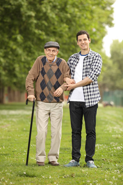 istock Grandson helping his grandfather in the park 694422474