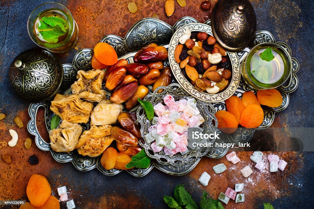 Ramadan Kareem holiday table Ramadan Kareem holiday table with dry fruits, nuts, dates, baklava. Eastern abundance. Copy space Eid-Ul-Fitr Stock Photo