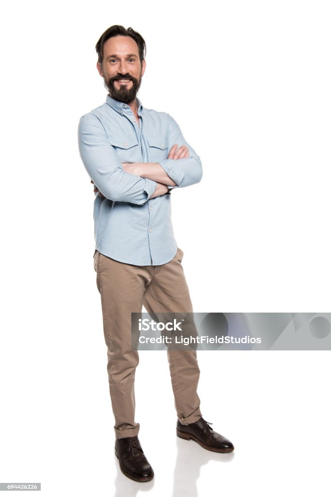 erwachsener Mann in Freizeitkleidung Stand mit verschränkten Armen und Blick in die Kamera, die isoliert auf weiss lächelnd - Lizenzfrei Männer Stock-Foto