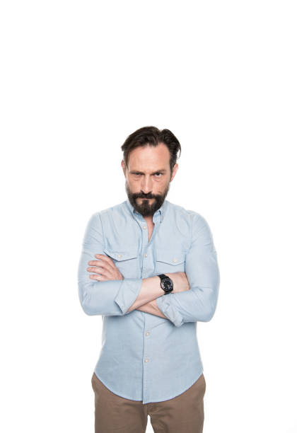 istock Serious bearded man standing with crossed arms and looking at camera 694429432