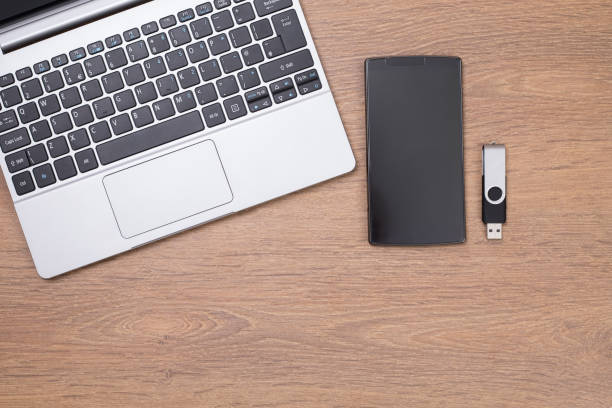 istock Laptop top with smart phone and USB stick 694432300