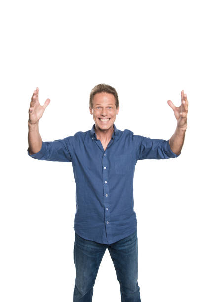 istock Cheerful middle aged man with open hands and looking at camera isolated on white 694432482