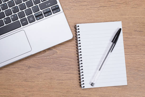 istock Aerial view of noepad on pen next to a laptop 694432578