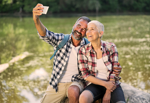 Mature couple hiking together, making selfie