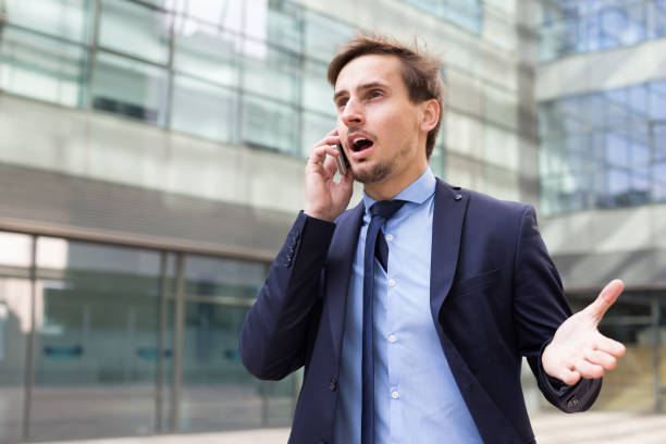 istock Young male in jacket talking on the phone 694457712