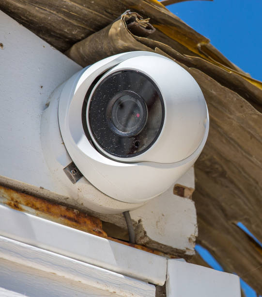 security cctv-kamera unter blauem himmel - vertical security camera security system security stock-fotos und bilder