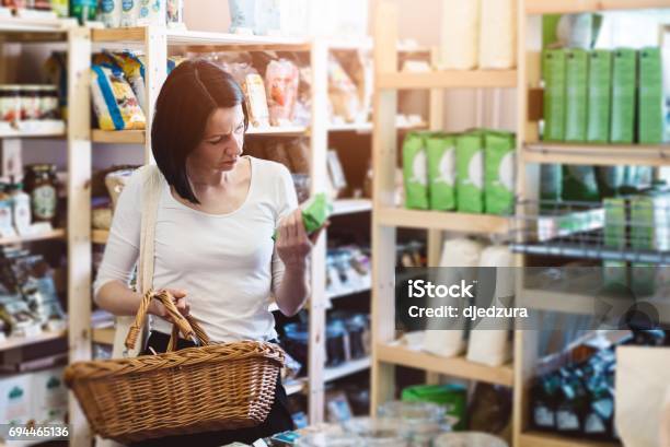 Woman Reading Product Information On Label Stock Photo - Download Image Now - Nutrition Label, Labeling, Food