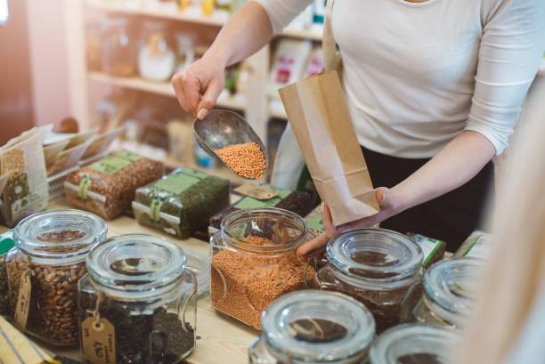 istock Woman puts lentil seeds into a paper bag 694465358