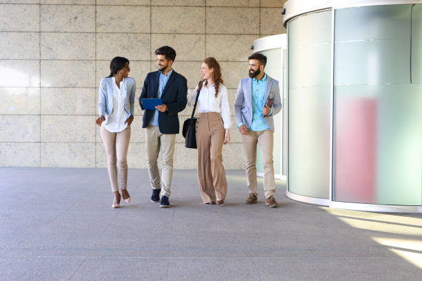 istock Four business colleagues having discussion while walking outside office 694466340