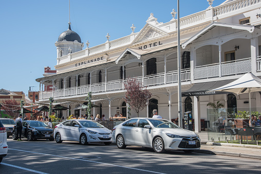 Fremantle,WA,Australia-November 13,2016: Outdoor cafe seating with sunshades and strung lights the the Esplanade Hotel with crowds in Fremantle, Western Australia