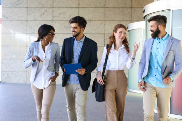 istock Four business colleagues having discussion while walking outside office 694474648