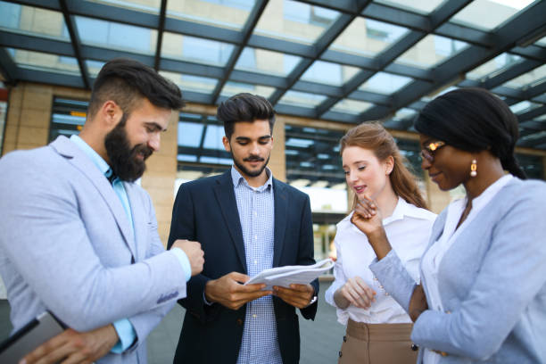 istock Four business colleagues discussing document outside office 694475108