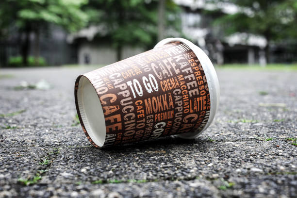 Used Coffee mug at sidewalk as symbol for pollution.