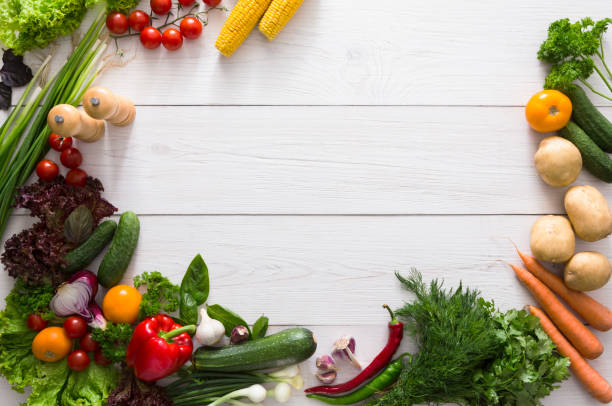 istock Border of fresh vegetables on white wood background with copy space 694481260