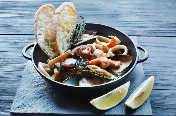 istock Seafood Stew in Saucepan on dark wood background 694485434