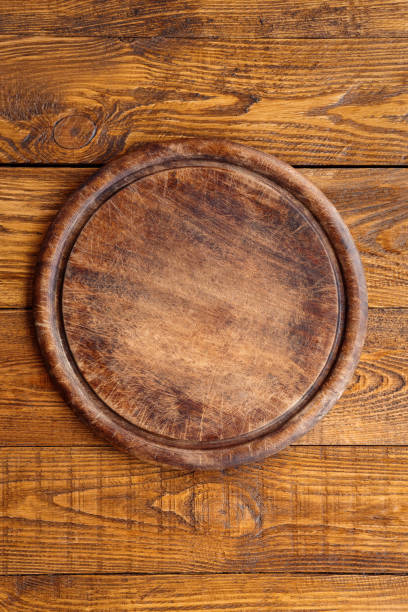 istock Wooden round board for pizza 694489694