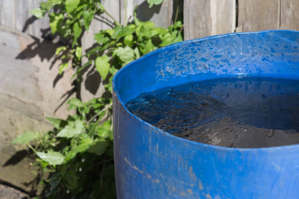 istock water pouring from roof to blue pot 694492106