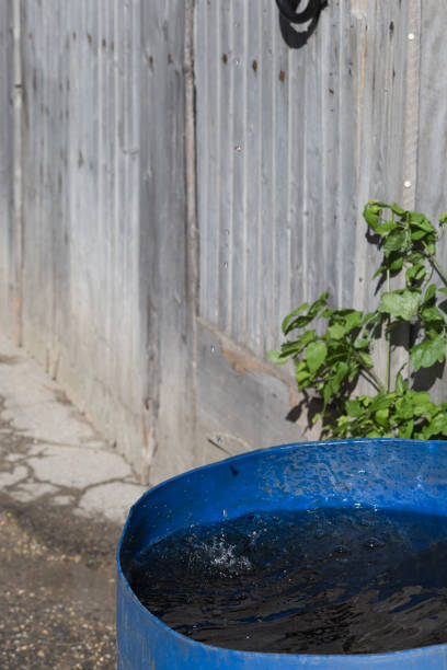 istock water pouring from roof to blue pot 694492258