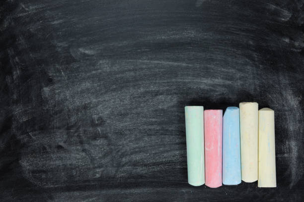 istock Sticks of colored chalk on a chalkboard 694502188