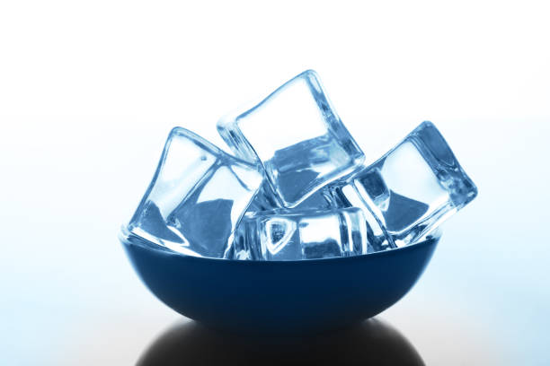 istock Transparent ice cubes bowl on white background with water drops 694504972