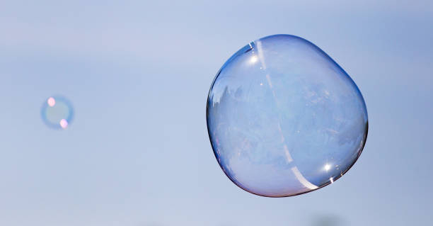 istock Big soap bubble against the blue sky 694507426