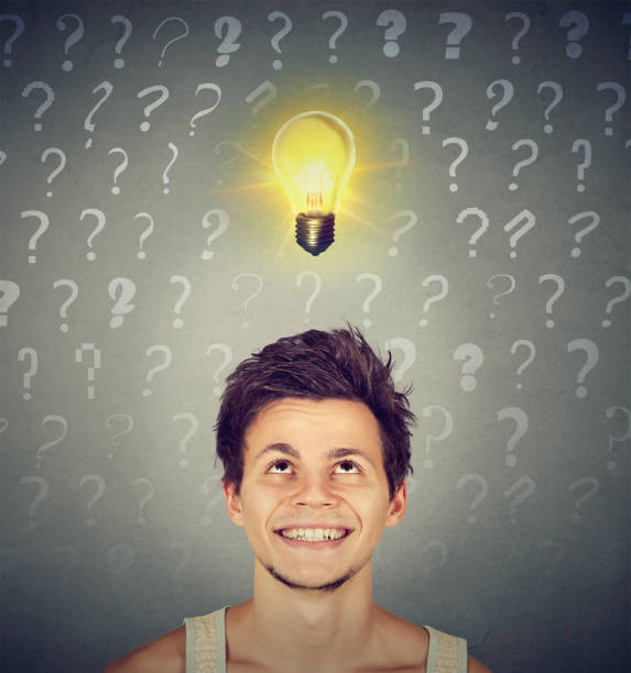 istock Happy man with idea light bulb and many questions above head 694511596