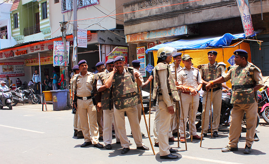 Madhya Pradesh police personal deployed on a road in alert position to handle any unwarranted situation in Ujjain, India.