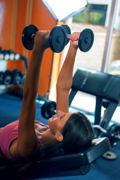 Woman exercising with dumbbells at a gym