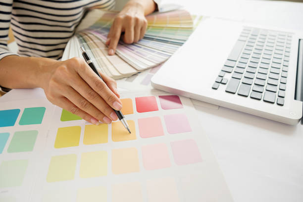 istock Graphic design and color swatches and pens on a desk. Architectural drawing with work tools and accessories. 694542166