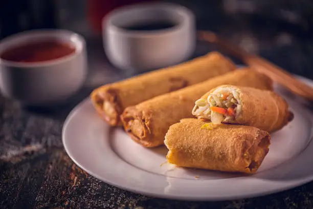 Spring rolls served on a plate with chili dipping and soy sauce