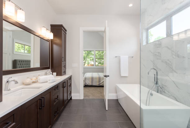 master bathroom interior in luxury home large mirror, shower, and bathtub. Includes dark hardwood cabinets and tile floor. View of bedroom Master bathroom with double vanity porcelain photos stock pictures, royalty-free photos & images